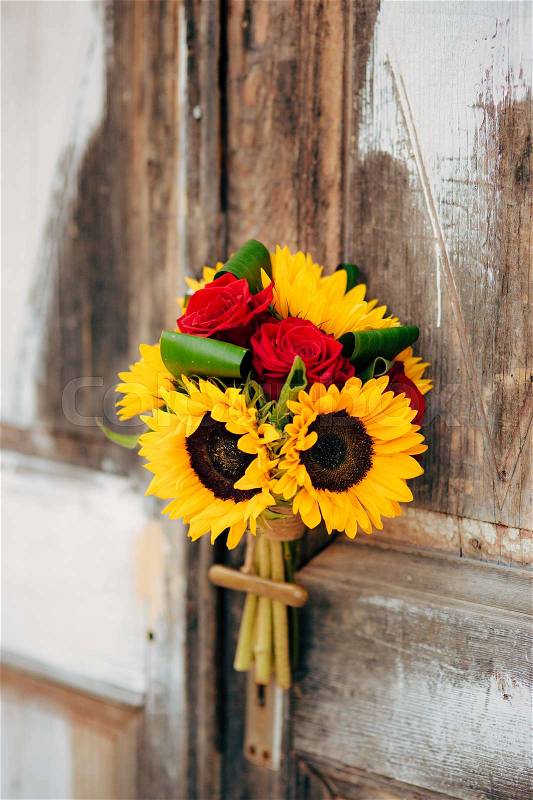 Wedding bridal bouquet of sunflowers on a background of white and gray shabby door. Wedding in Montenegro, Perast, stock photo