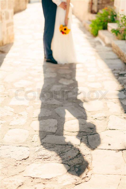 The shadow of the couple on the floor. Silhouette of the shadow of the newlyweds on the asphalt in Montenegro, stock photo