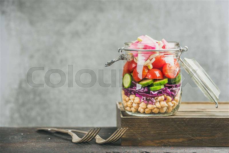 Healthy take-away lunch jar. Vegetable and ckickpea sprout vegan salad in glass jar, grey concrete wall background, copy space, selective focus. Clean eating, vegetarian, detox, raw food, dieting concept, stock photo