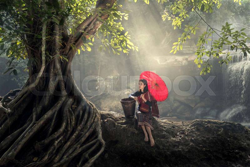 Asian young woman relaxing in nature. with red umbrella in green forest, stock photo