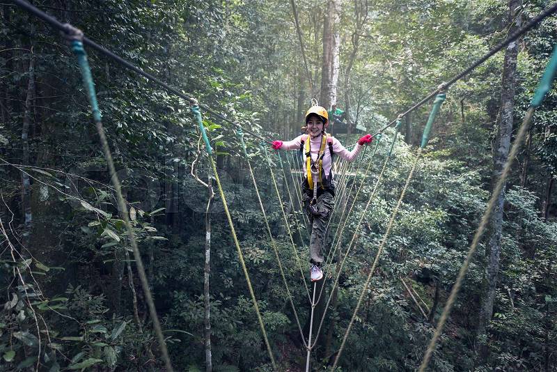 Woman on cables in an adventure park on a difficult course, stock photo