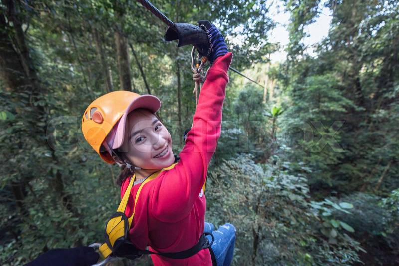 Woman Tourist Wearing Casual Clothing On Zip Line Or Canopy Experience In Laos Rainforest, Asia, stock photo
