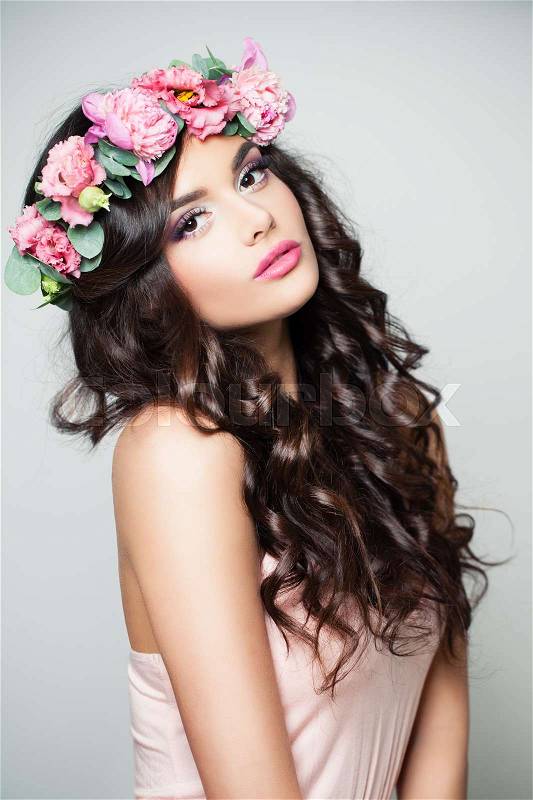 Spring Fashion Portrait of Beautiful Model Woman with Makeup, Flowers and Long Curly Hair, stock photo