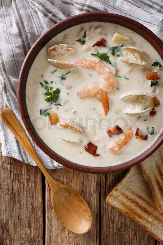 American food: New England clam chowder soup close-up on a in a bowl on the table. Vertical view from above , stock photo