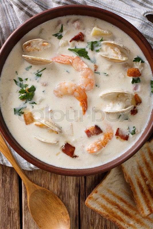 New England clam chowder soup close-up on the table. Vertical view from above , stock photo