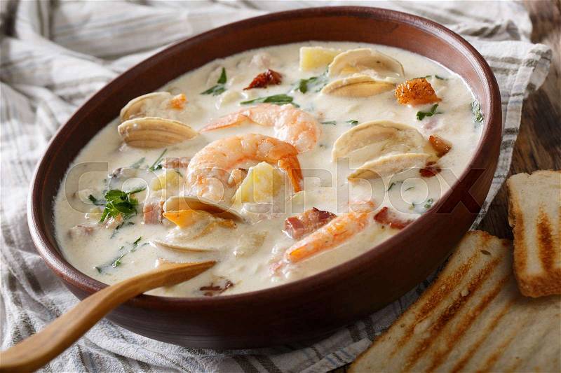 Delicious clam chowder soup with shellfish and bacon close-up on a in a bowl on the table. horizontal , stock photo