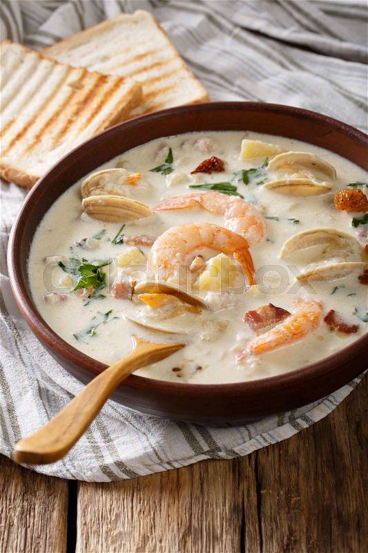 American food: New England clam chowder soup close-up on a in a bowl on the table. vertical , stock photo