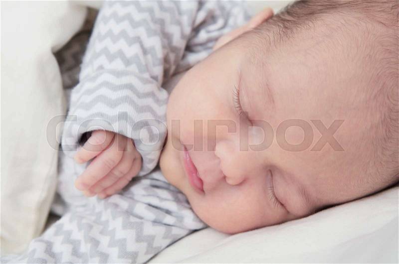 Cute newborn baby boy sleeping, one month old, face closeup, stock photo