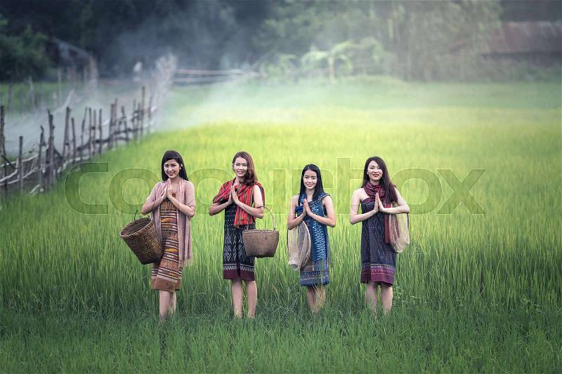 Thai women welcome sawasdee at rice field, countryside of Thailand, stock photo