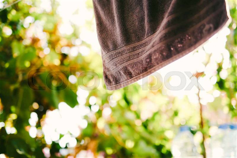 A purple towel is dried on the balcony. Green background in blur, stock photo