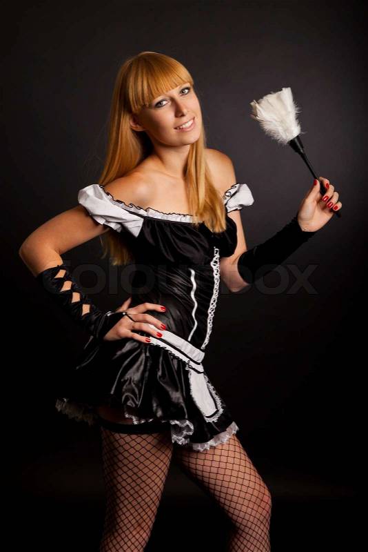 Beautiful caucasian woman dressed in a French Maid costume isolated on a black background, stock photo