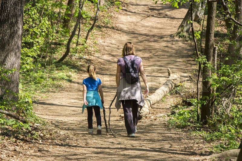 Mother and daughter walking in spring forest, stock photo