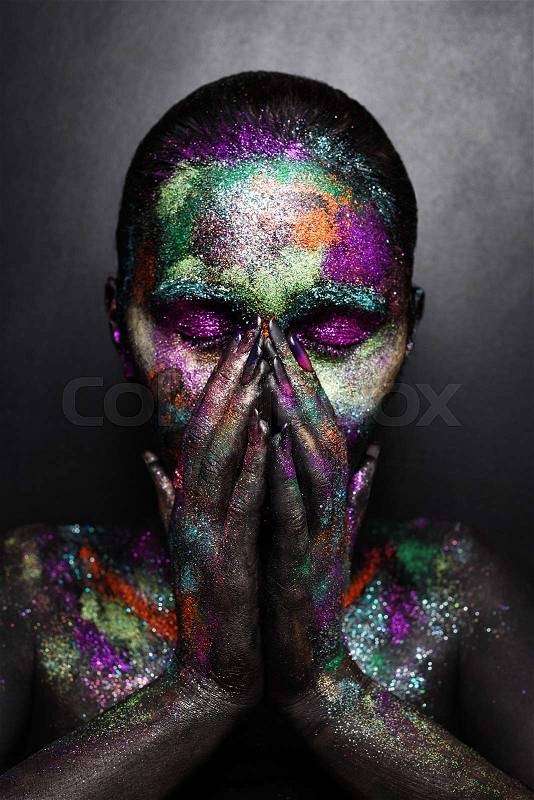 Young artistic woman in black paint and colourful powder. Glowing dark makeup. Creative body art on the theme of space and stars. Bodypainting project: art, beauty, fashion, stock photo
