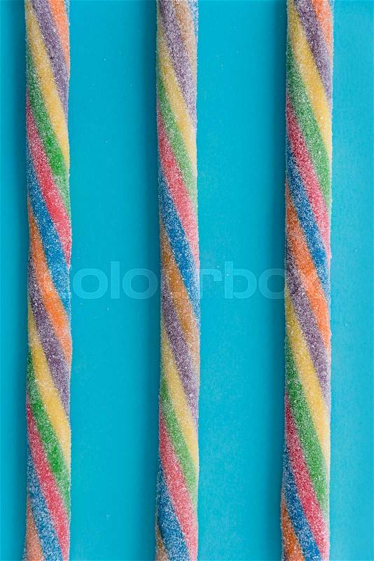 Top view of a colorful twisted licorice candy over blue background, stock photo