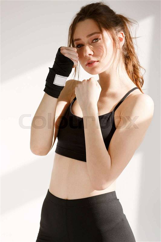 Picture of incredible young concentrated sports woman boxer standing over white background. Looking at camera, stock photo