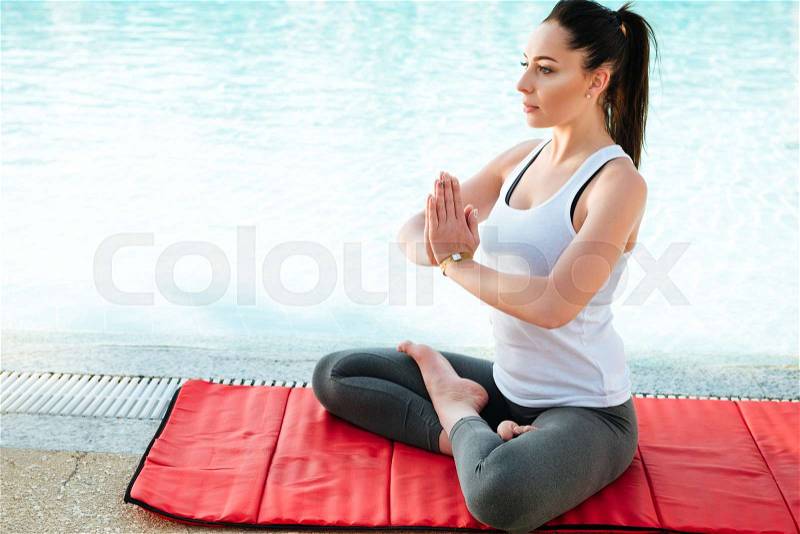 Picture of amazing young fitness lady make yoga exercises outdoors near pool, stock photo