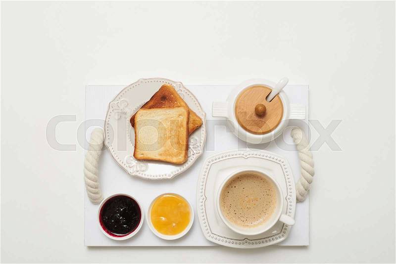 Flay lay of toasts with jams and coffee served on service tray isolated white background , stock photo