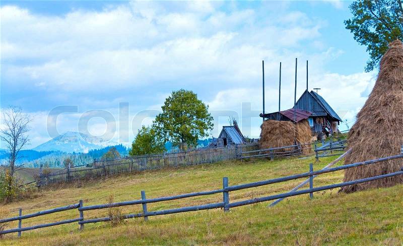 Autumn countryside landscape with village on mountainside, stock photo
