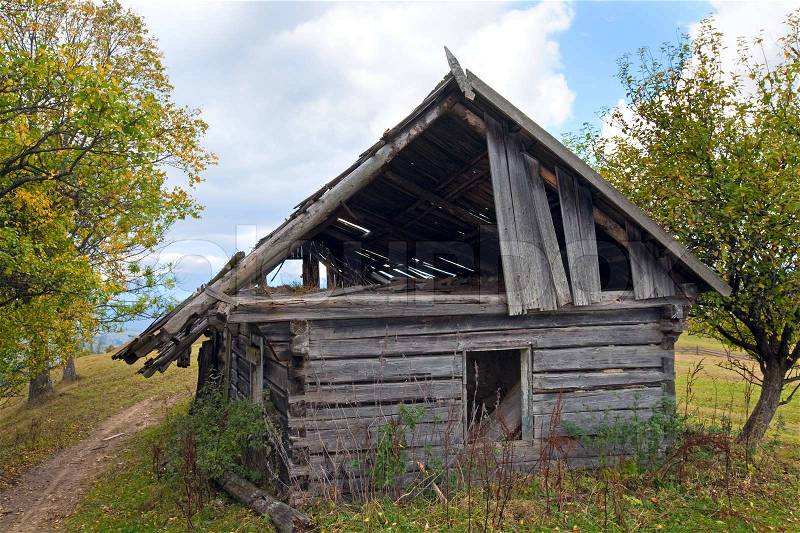 Ruined wood shed on mountain glade, stock photo