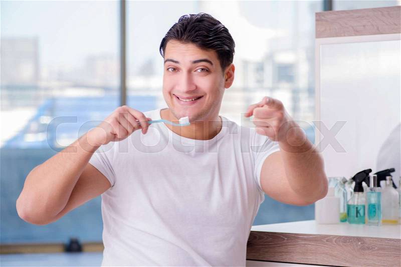 Handsome man brushing teeth in the morning, stock photo