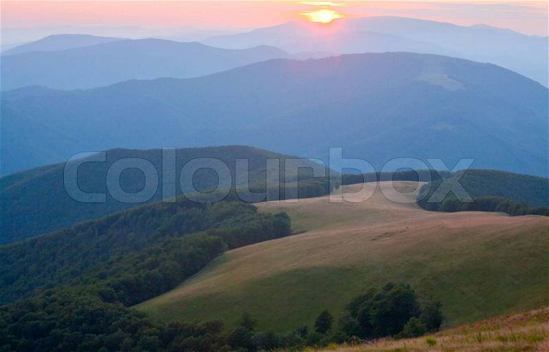 Autumn sunrise mountain view with haze, forest and sun on sky (Carpathian, Ukraine), stock photo