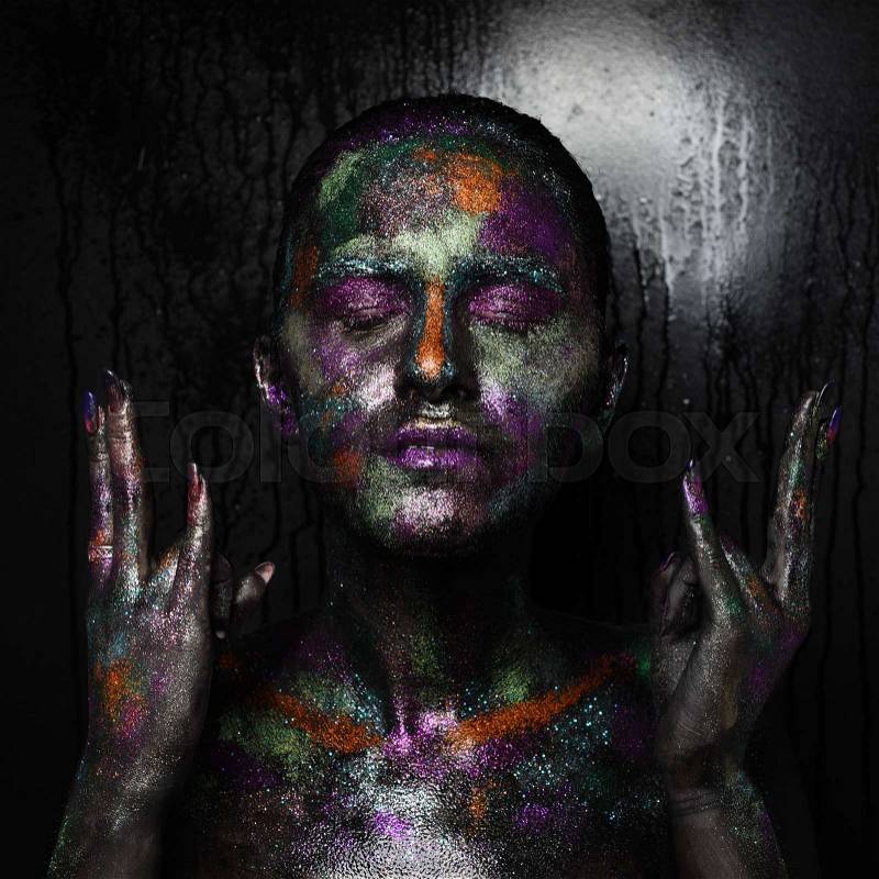 Young artistic woman in black paint and colourful powder. Glowing dark makeup. Creative body art on the theme of space and stars. Bodypainting project: art, beauty, fashion, stock photo