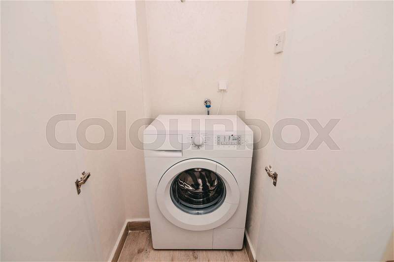Washing machine in apartment, close up. Storage room for washing, stock photo