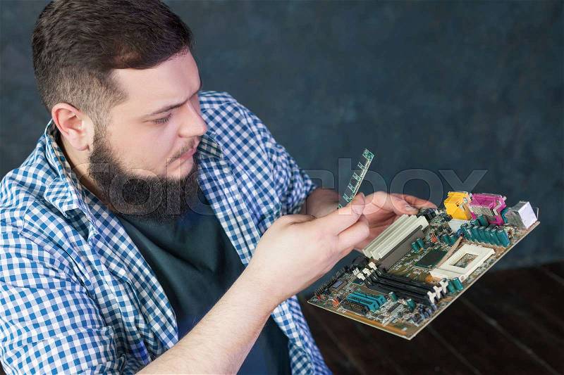 Service engineer fixing problem with pc hardware. Computer electronic components repairing technology, stock photo