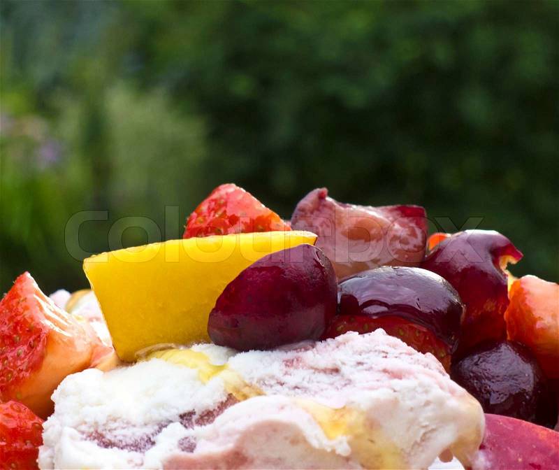 Fresh Assorted Fruit And Ice Cream Eaten Outside In Summer, stock photo
