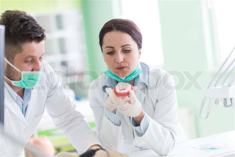 Dental prosthesis, dentures, prosthetics work. Dental students while working on the denture, false teeth, a study and a table with dental tools, stock photo