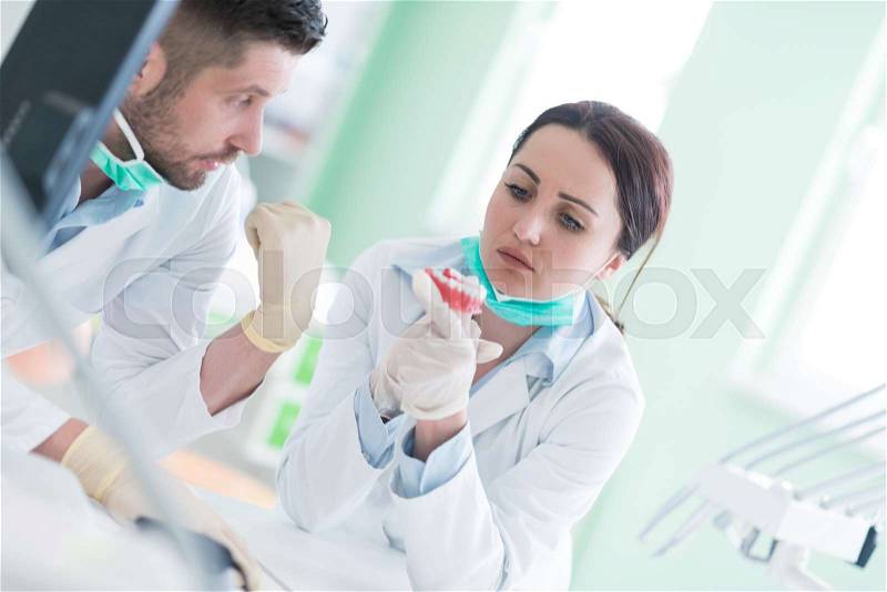 Dental prosthesis, dentures, prosthetics work. Dental students while working on the denture, false teeth, a study and a table with dental tools, stock photo