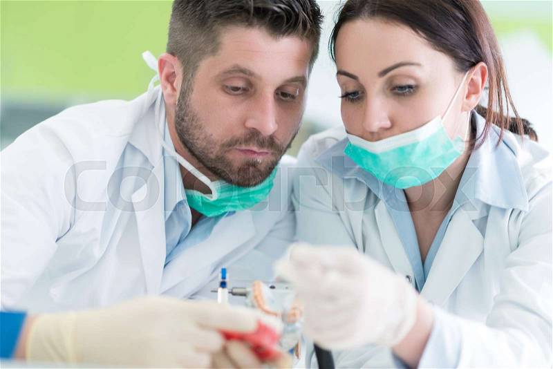 Closeup of dentistry student practicing on a medical mannequin, stock photo