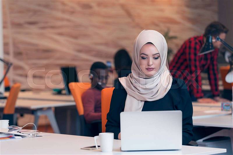 Young Arabic business woman wearing hijab,working in her startup office. Diversity, multiracial concept, stock photo