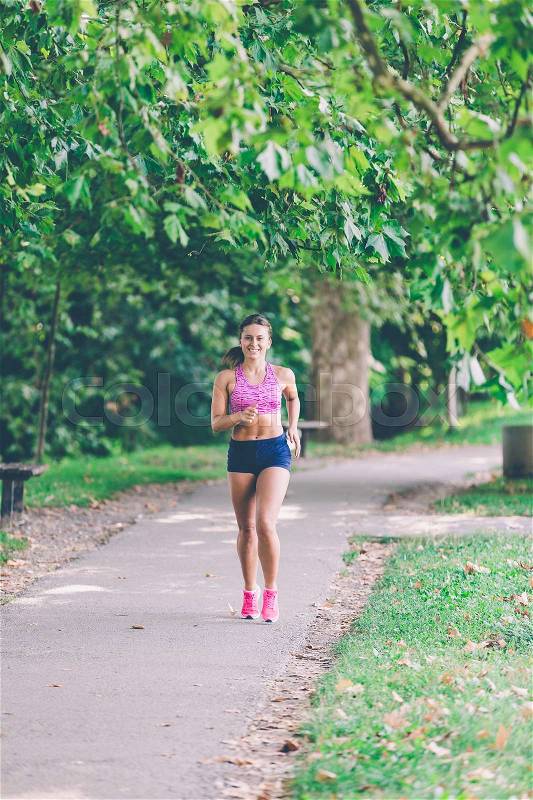 Runner athlete running at tropical park. woman fitness jogging workout wellness concept, stock photo