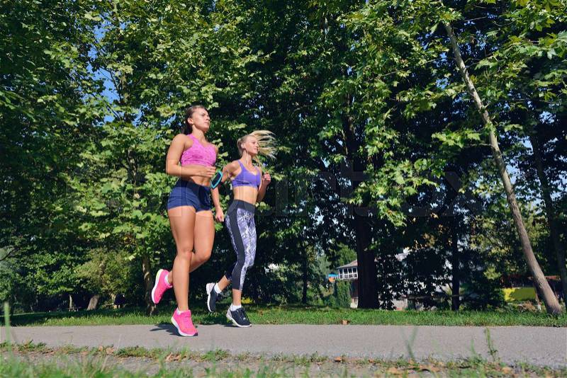 Two woman practicing working out - fitness outdoor at the park, stock photo