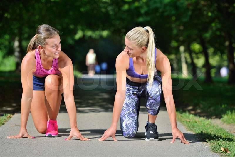 Two woman practicing working out - fitness outdoor at the park, stock photo