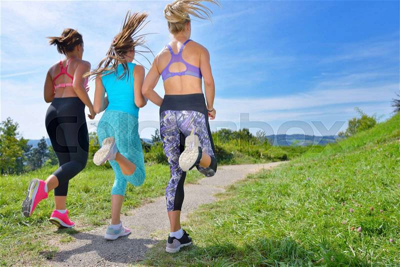 Three Female Joggers running together on trail outdoors, stock photo