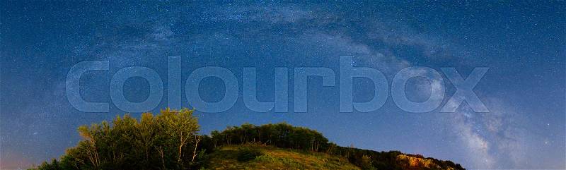 The starry sky and the Milky Way over the mountains and the forest, stock photo