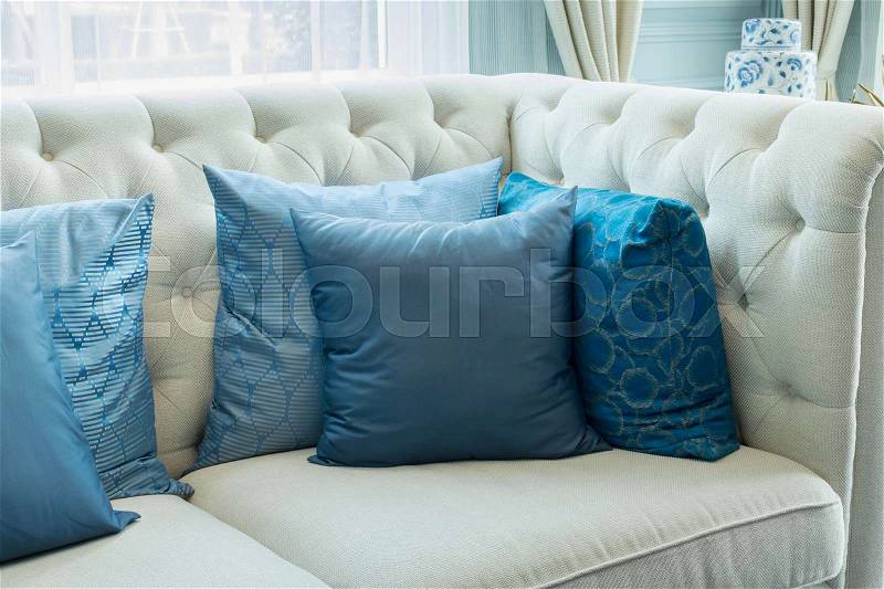 Luxury living room interior with blue pattern pillows on sofa, stock photo