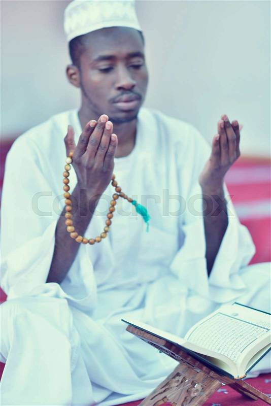 African Muslim Man Making Traditional Praying To God While Wearing A Traditional Cap Dishdasha, stock photo