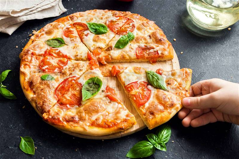People Hand Taking Slice Of Pizza Margherita. Pizza Margarita and Child Hand close up, stock photo