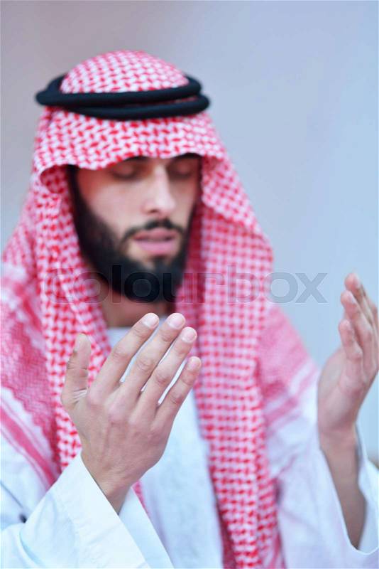 Handsome Younger Muslim Arabic man praying in mosque, stock photo