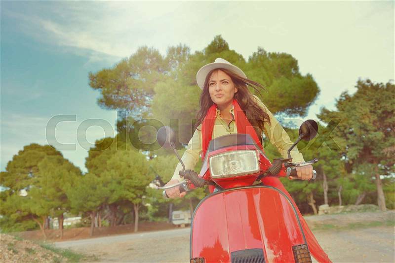 Young beautiful italian woman sitting on a italian scooter in Italy hills, stock photo