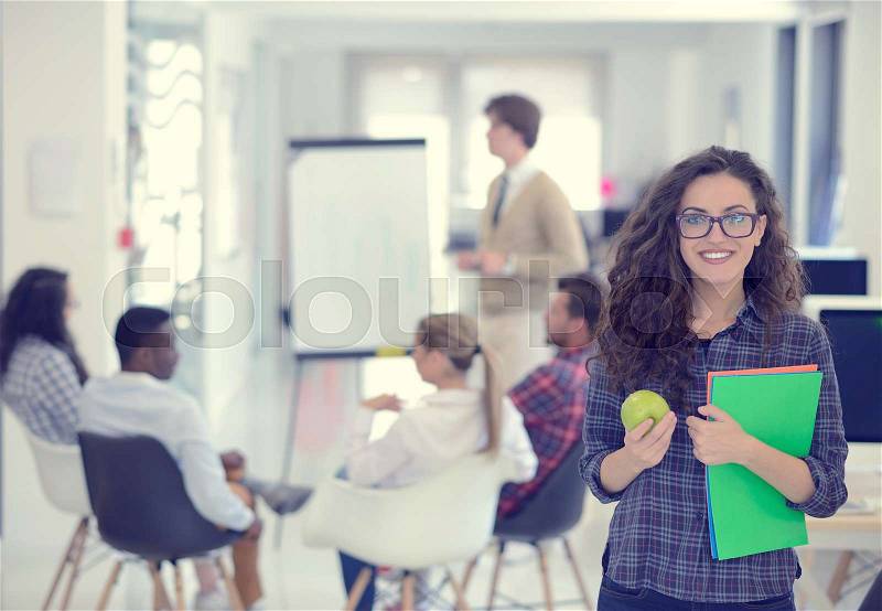 Business, startup and people concept - happy creative team with computer and folder in office, stock photo