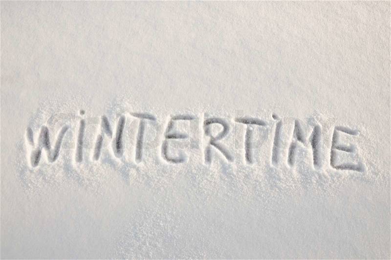 Written word wintertime on a snow field, stock photo