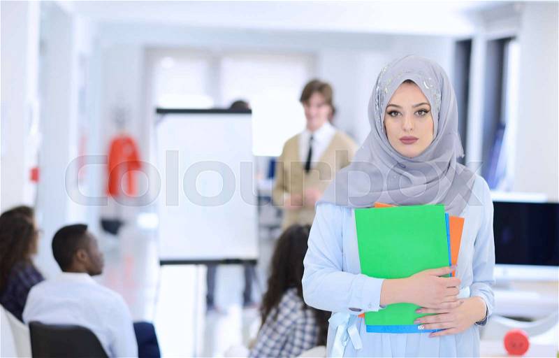 Arabic business woman working in team with her colleagues at startup office, stock photo
