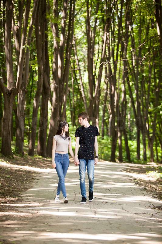 Happy couple taking a walk in the forest. Lifestyle and relationship. Young inlove boyfriend and girlfriend, stock photo