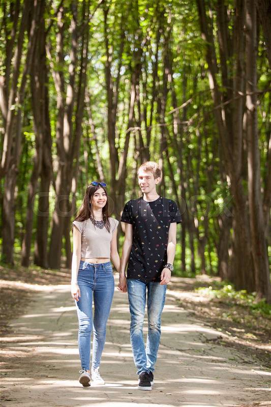 Couple taking a walk in the forest. Lifestyle and relationship. Young inlove boyfriend and girlfriend, stock photo