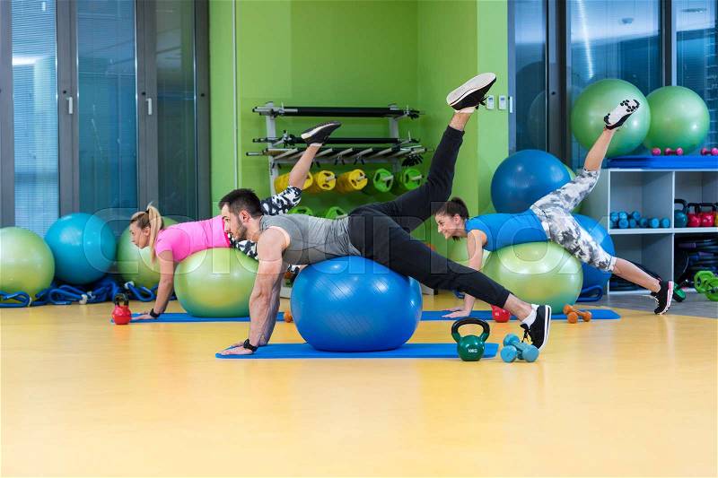 Portrait of happy group exercising on Swiss ball, stock photo