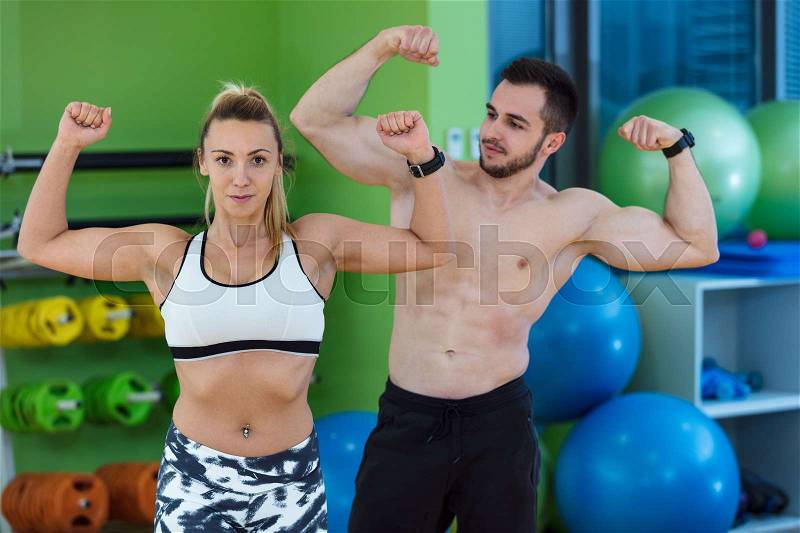 Sexy caucasian man and woman in gym couple train in fitness club with weights lifestyle wellness exercising with joy, stock photo
